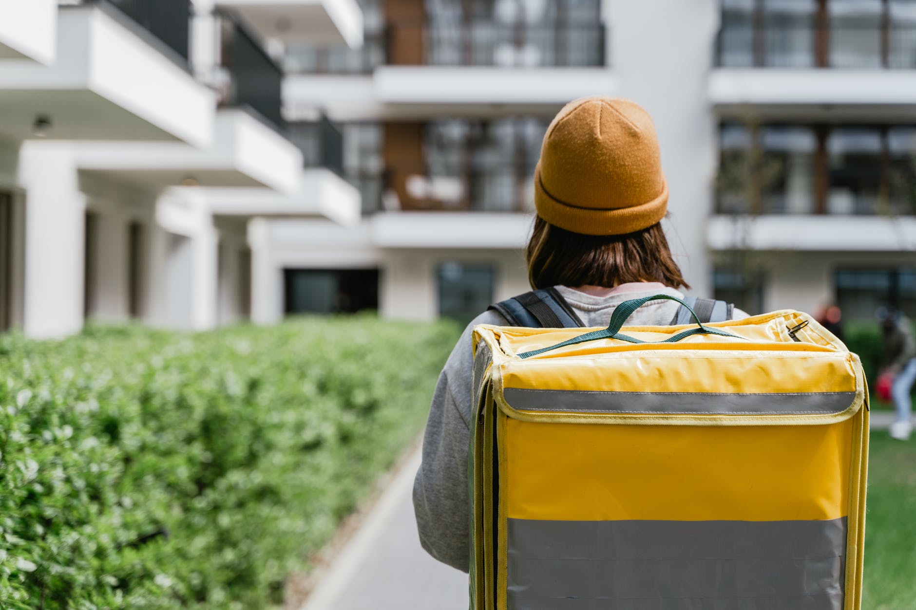 A food delivery courier brings a food delivery order to a multifamily residential building.