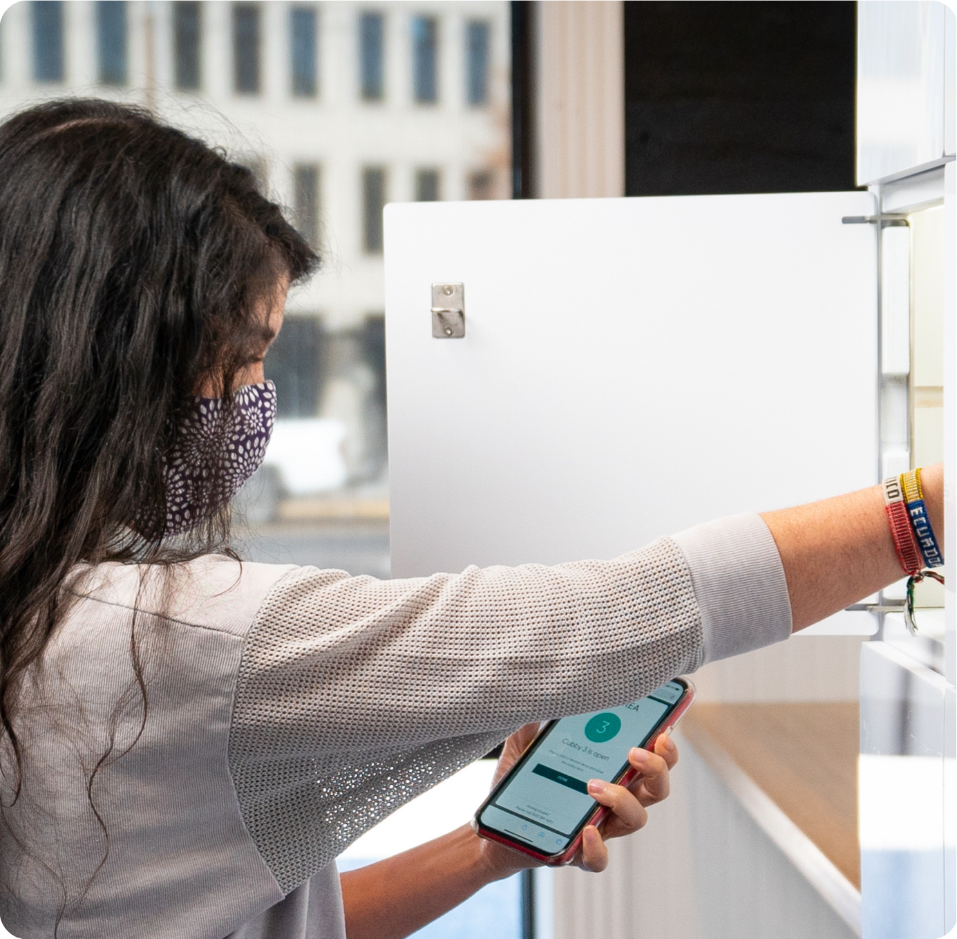 Woman reaching into food delivery locker.