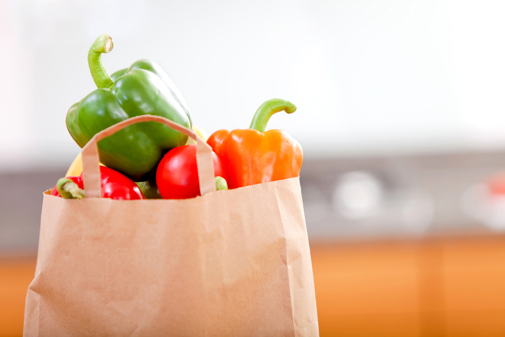 A paper shopping bag full of groceries