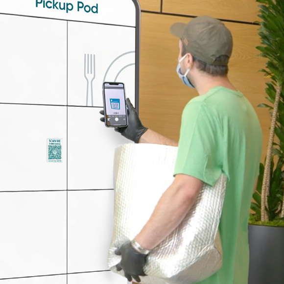 A foodservice delivery courier scanning the code on the front of the Pickup Pod.