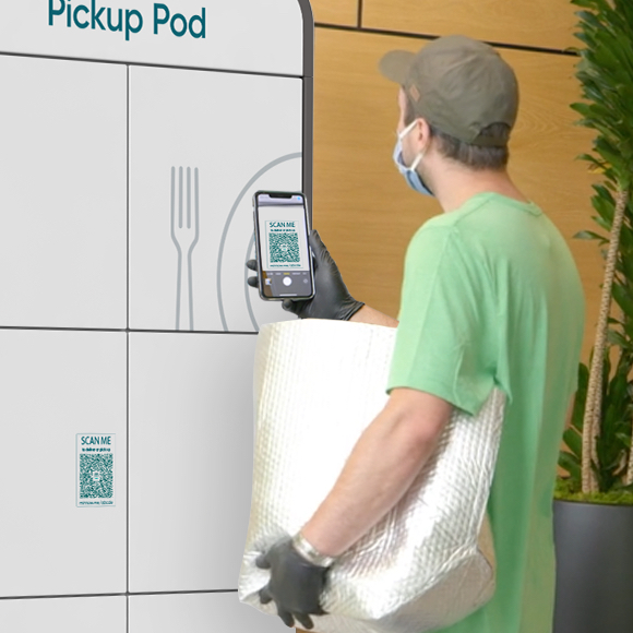 A foodservice delivery courier scanning the code on the front of the Pickup Pod.
